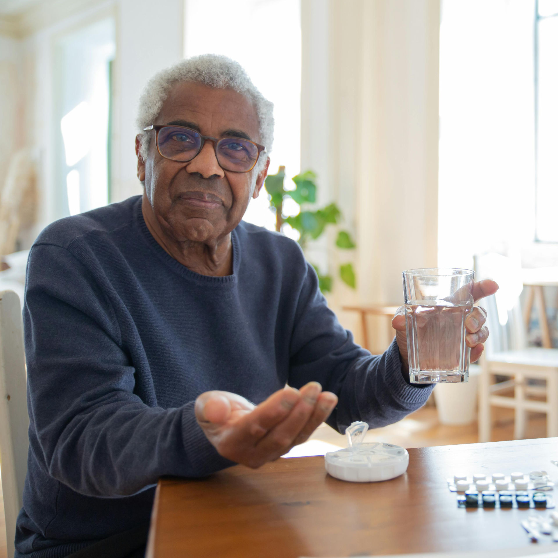 Mario con i suoi farmaci sul tavolo di casa